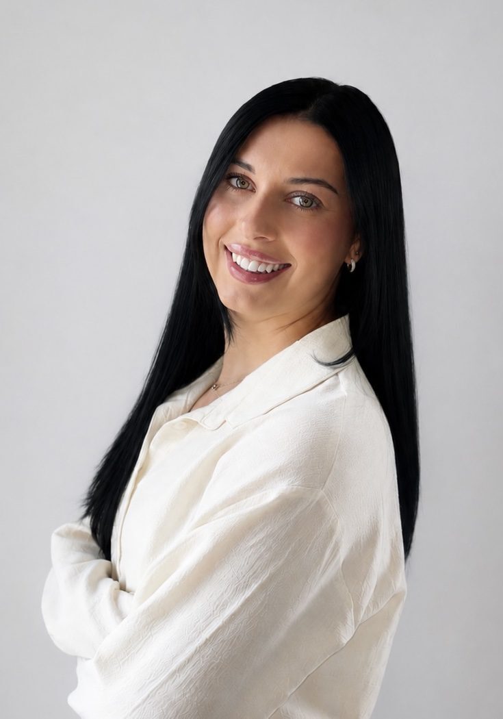 Woman smiling in cream blouse, arms crossed